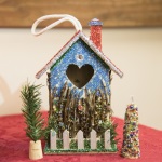 The bird house is adorned with jewelry beads, sparkle pipe cleaner, glitter glue, and a touch of garland.