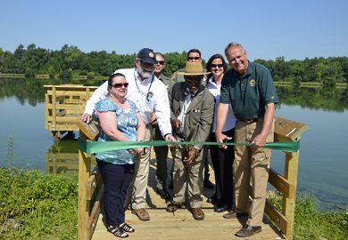 S.C. State Rep. Lonnie Hosey (center) joined SCDNR officials and Thoroughbred Country Regional Tourism Marketing Director Mary Ann Keisler (left) at a ribbon cutting ceremony for a new handicapped-accessible fishing pier at Lake Edgar Brown in Barnwell. [SCDNR photo by D. Lucas]