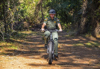 SCDNR Lance Corporal Jeff Day tests the Pedego electric bicycle. [SCDNR photo by David Lucas]