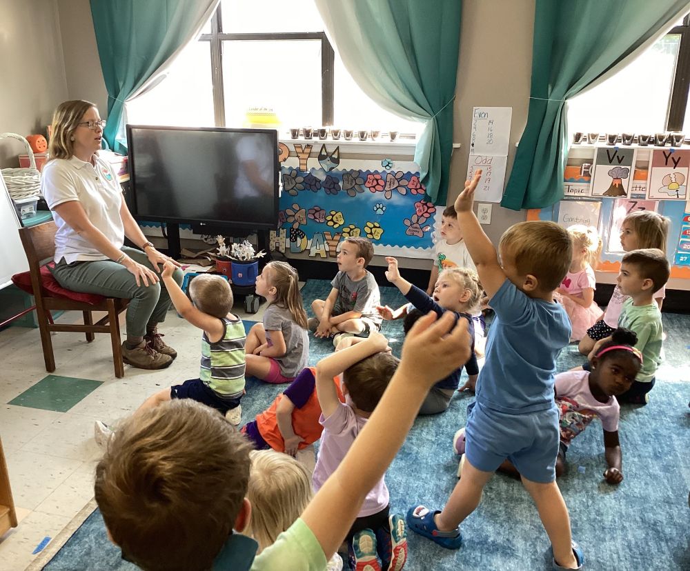 Two SCDNR employees standing by a table at the zoo, setup for a talk