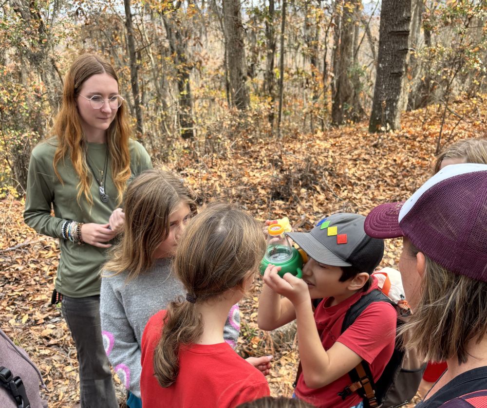 A SCDNR employee standing with children on an educational tour.