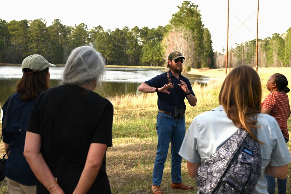 Scdnr Employee leading an educational talk in a grassy field