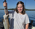 a girl holding a Brown trout