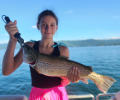 a younger lady holding brown trout