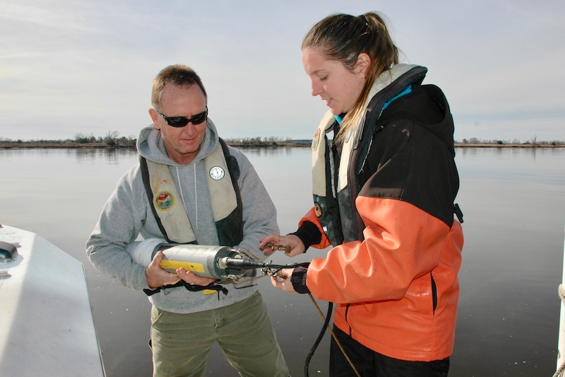 Researchers aboard a boat setting up monitoring equipment