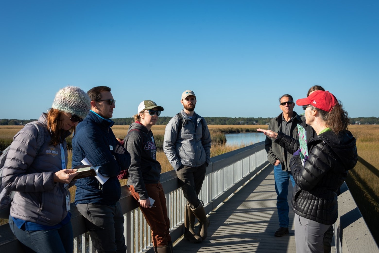 A class on the beach surrounding an instructor